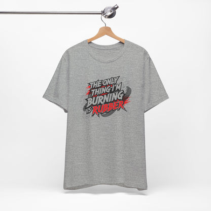 Gray t-shirt with a graphic design and text 'The only thing I'm burning is rubber' on a hanger against a white background