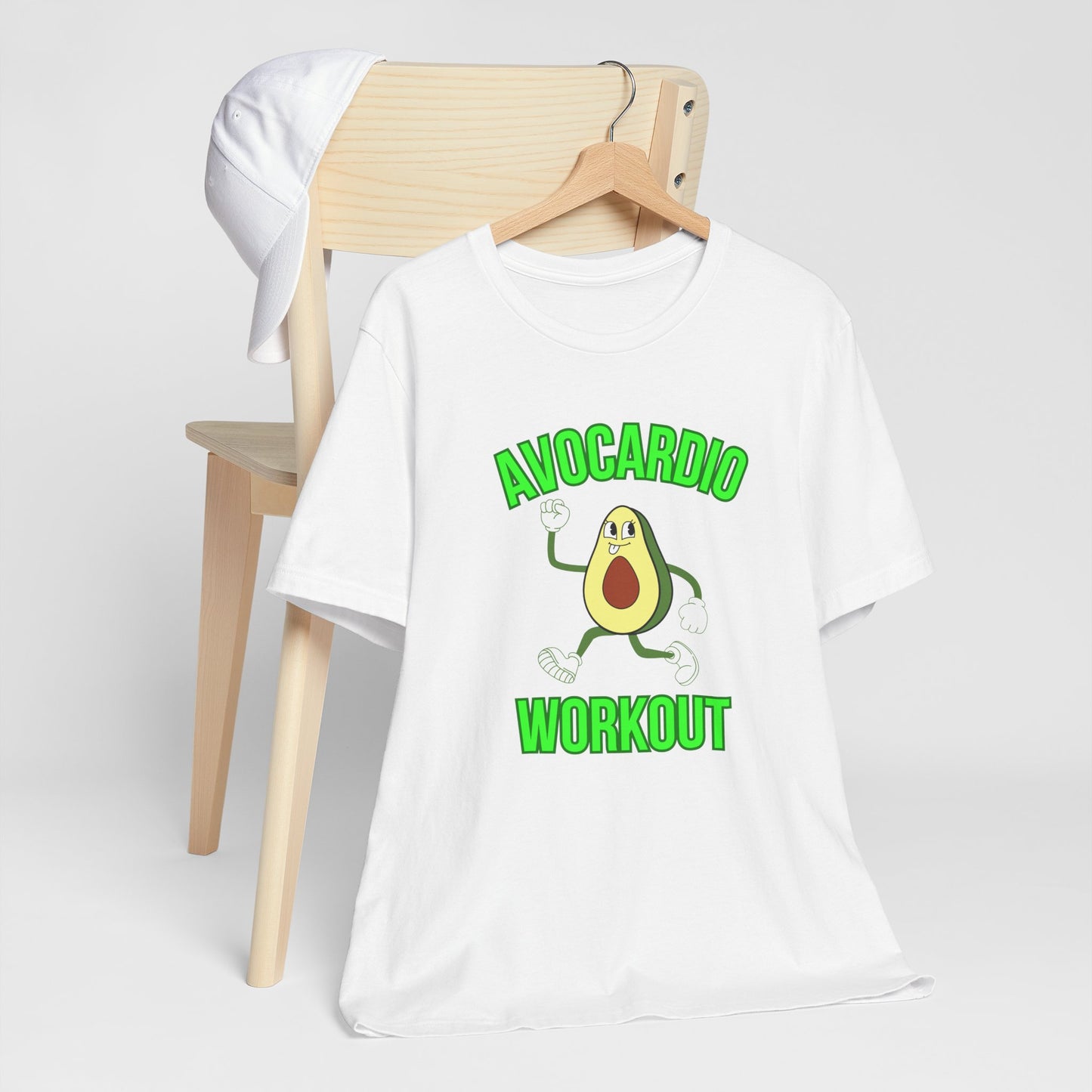 White t-shirt with avocado graphic and text 'Avocardio workout' on a wooden chair against a white background