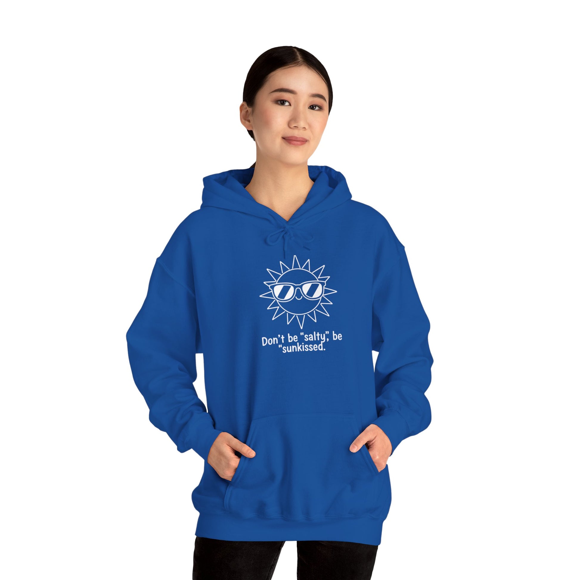 Person wearing a blue hoodie with a sun graphic and text 'Don't be salty, be sunkissed' on a white background
