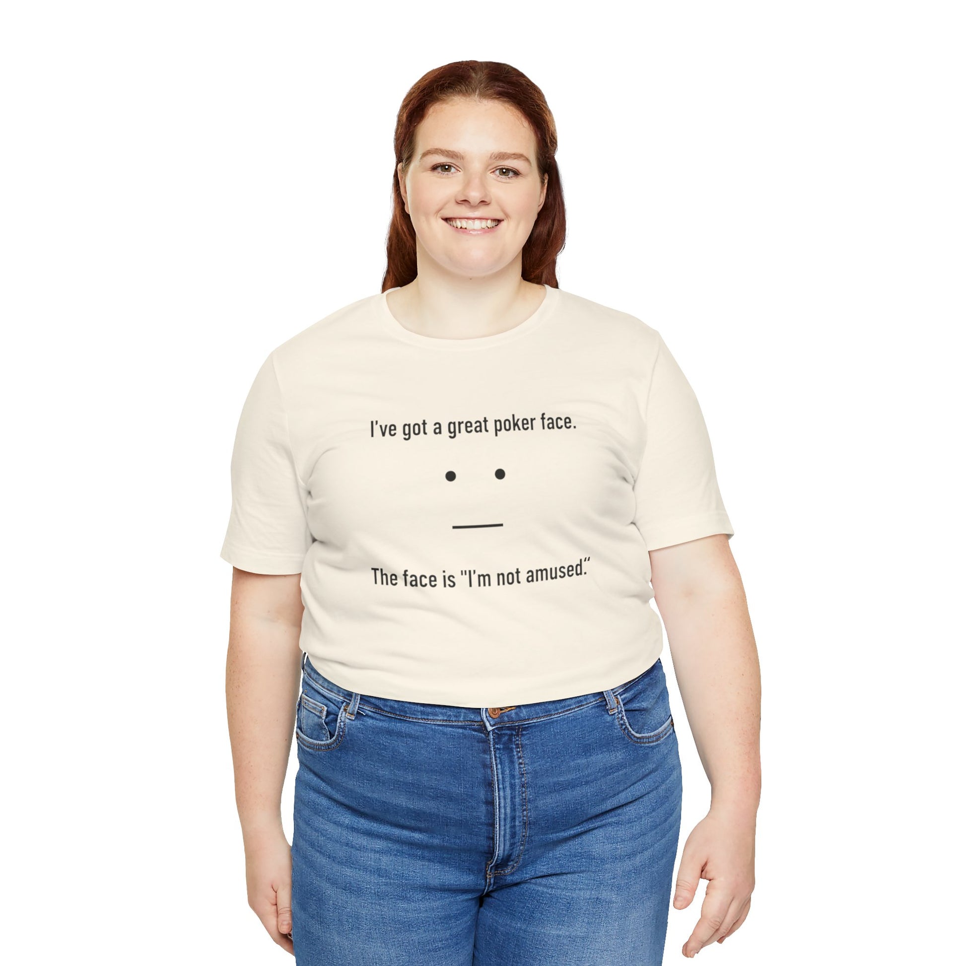 Person wearing a natural t-shirt with text 'I've got a great poker face. The face is I'm not amused.' and a face graphic on a white background
