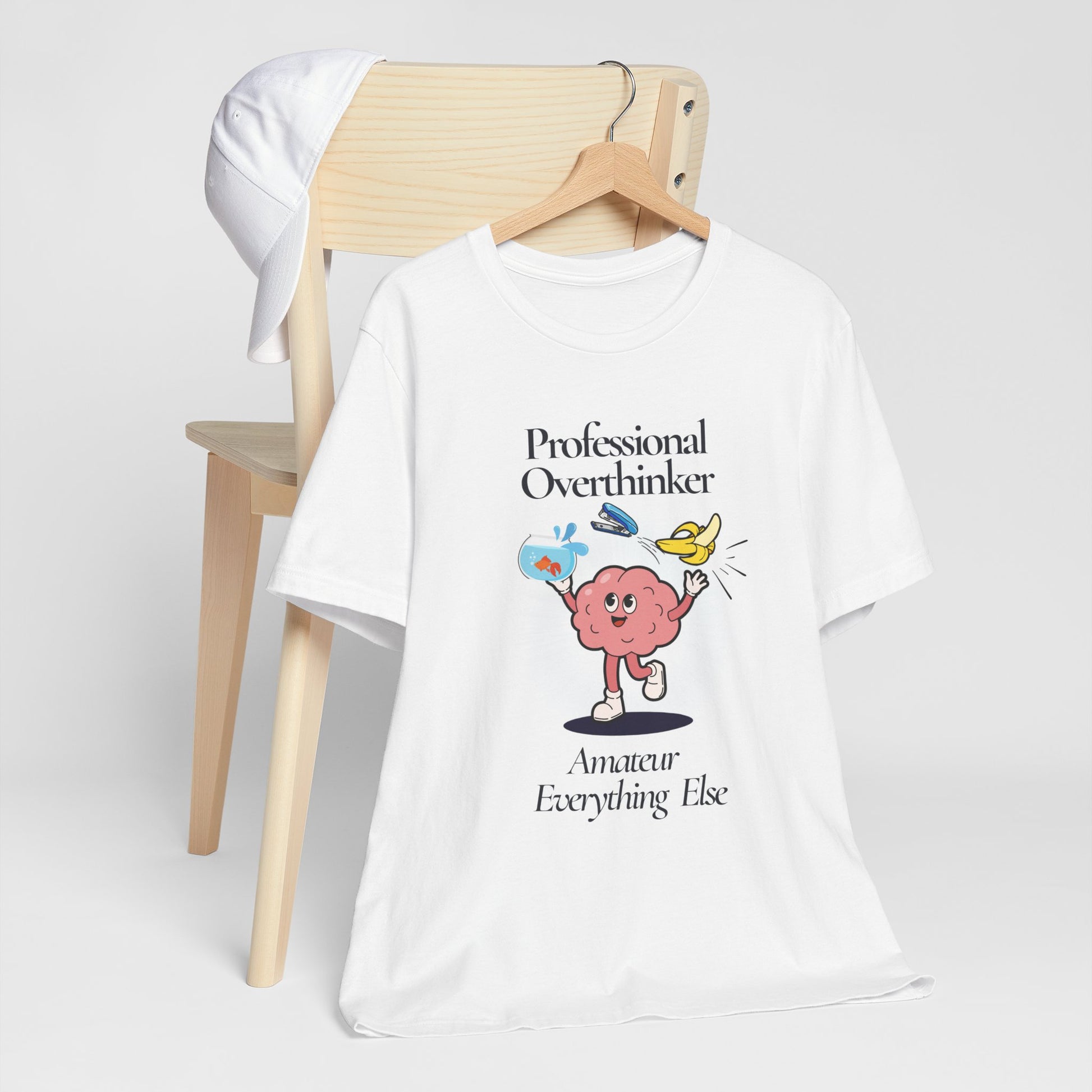 White t-shirt with a graphic design and text 'Professional Overthinker, Amateur Everything Else' on a white background