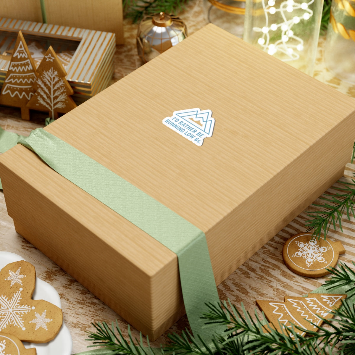 Wooden gift box with a green ribbon on a festive background with cookies and decorations.