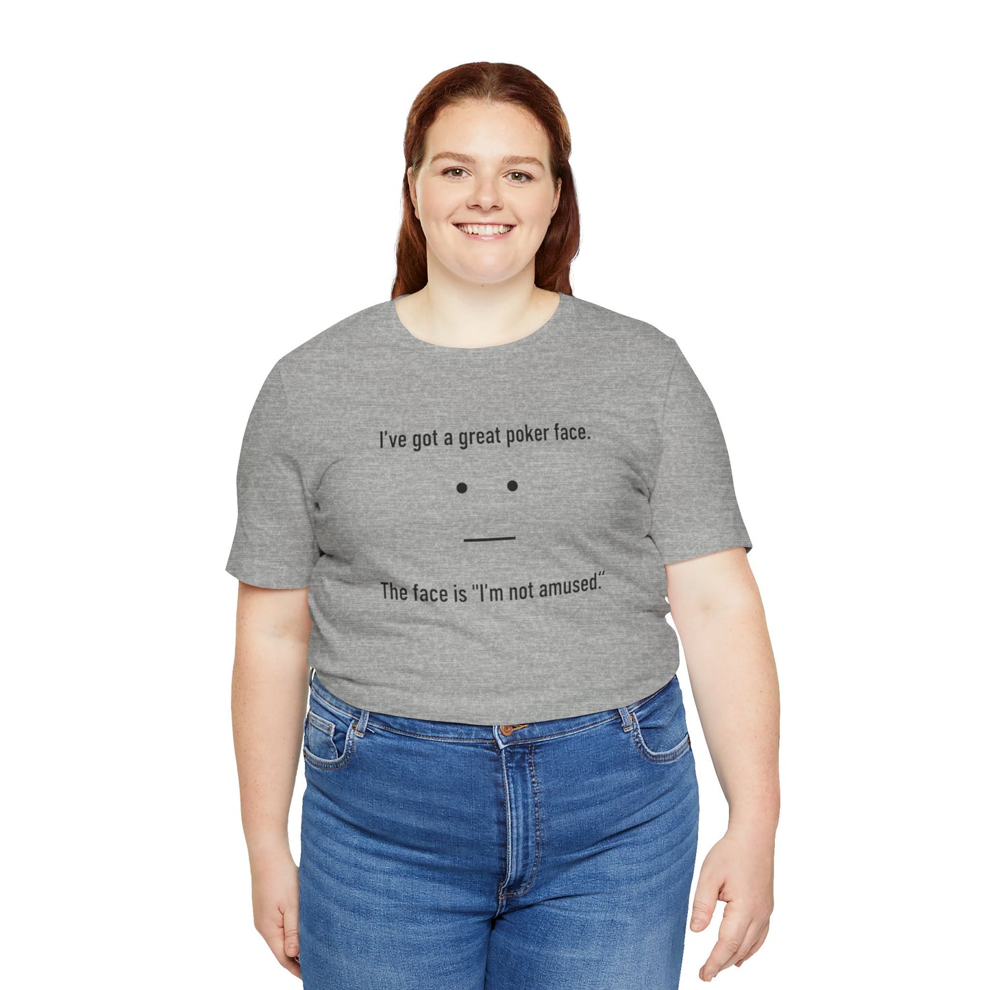 Person wearing a gray t-shirt with text 'I've got a great poker face. The face is I'm not amused.' and a face graphic on a white background