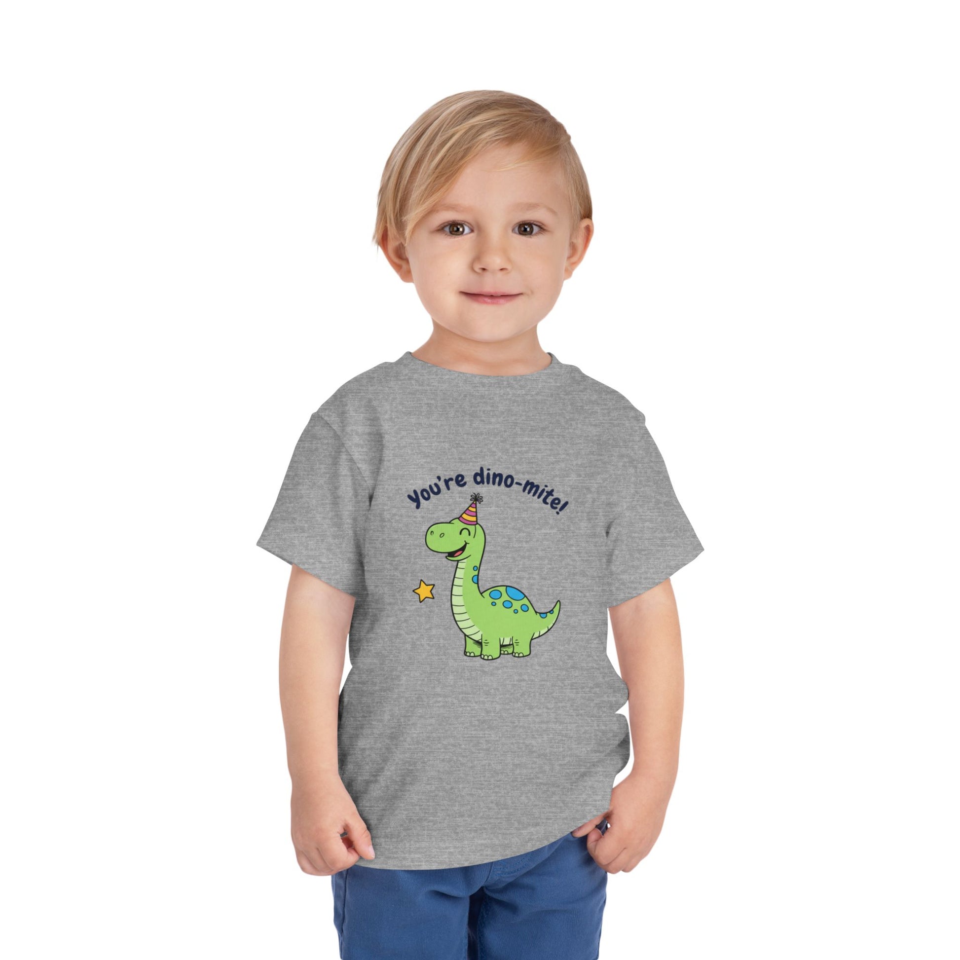 Child wearing a gray t-shirt with a dinosaur graphic and text on a white background