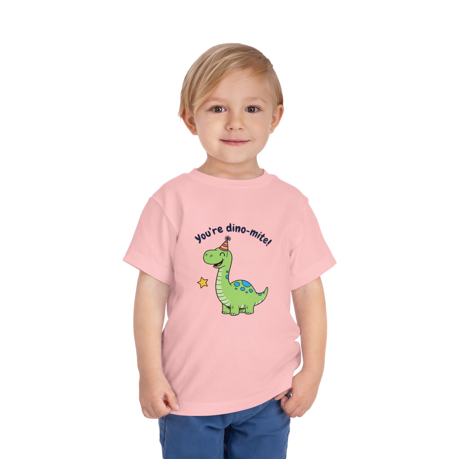 Child wearing a pink t-shirt with a dinosaur graphic and text on a white background