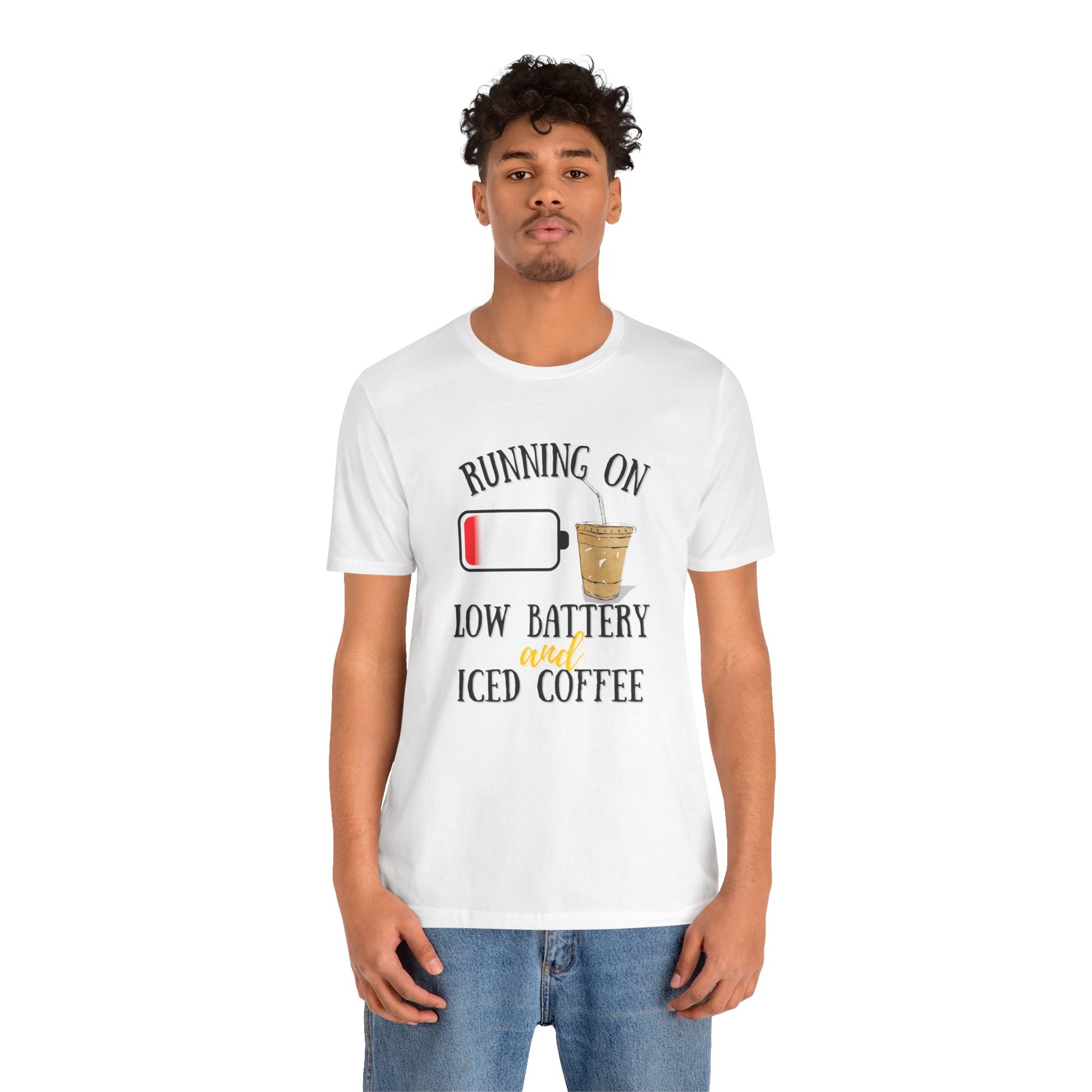 Person wearing a white t-shirt with a humorous graphic and text 'Running on low battery and iced coffee' on a white background