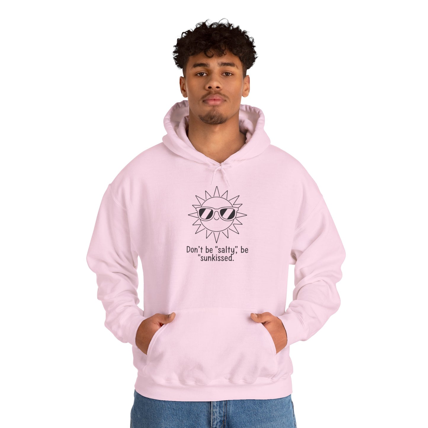 Person wearing a pink hoodie with a sun graphic and text 'Don't be salty, be sunkissed' on a white background