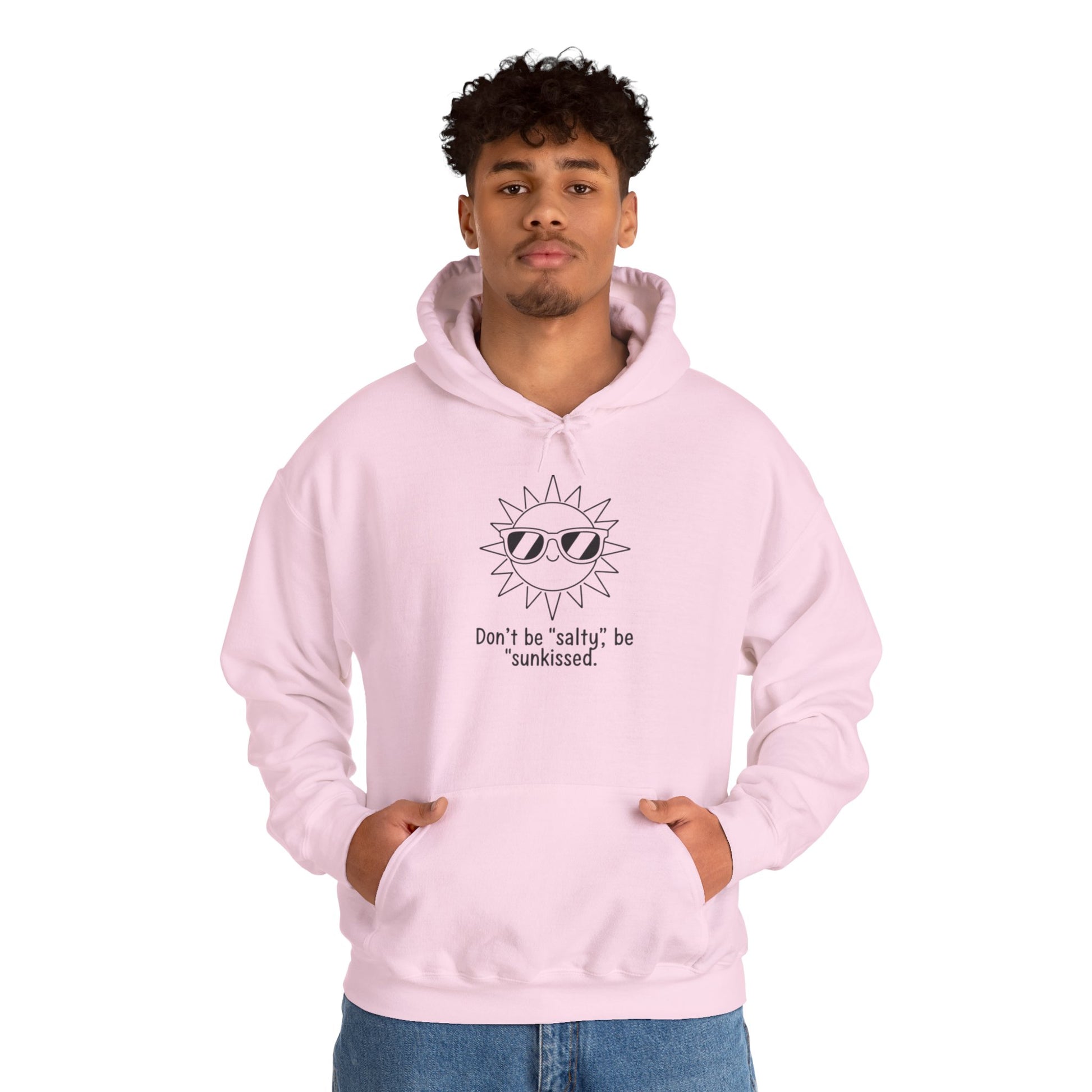 Person wearing a pink hoodie with a sun graphic and text 'Don't be salty, be sunkissed' on a white background