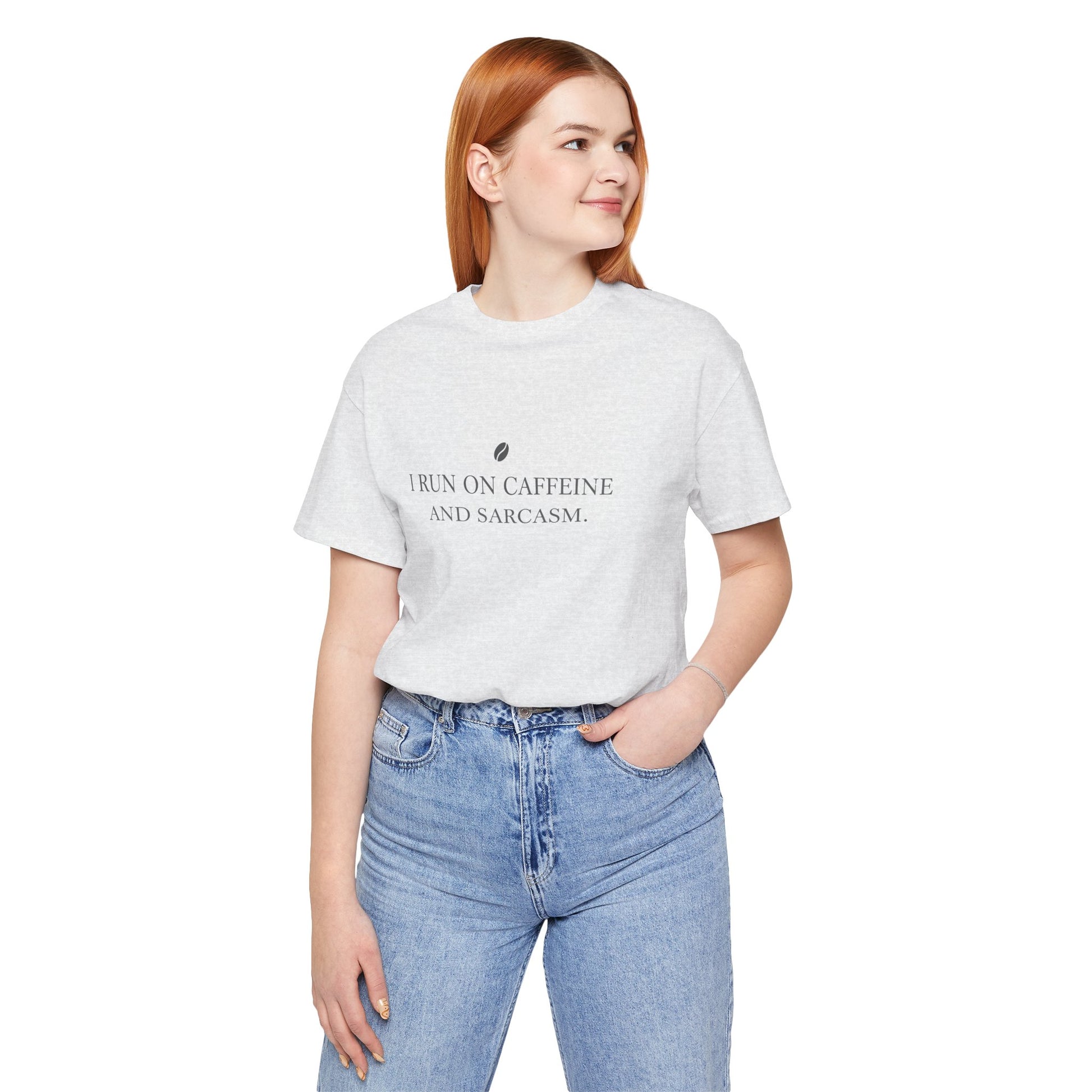 Person wearing a white t-shirt with text 'I run on caffeine and sarcasm' and blue jeans on a white background