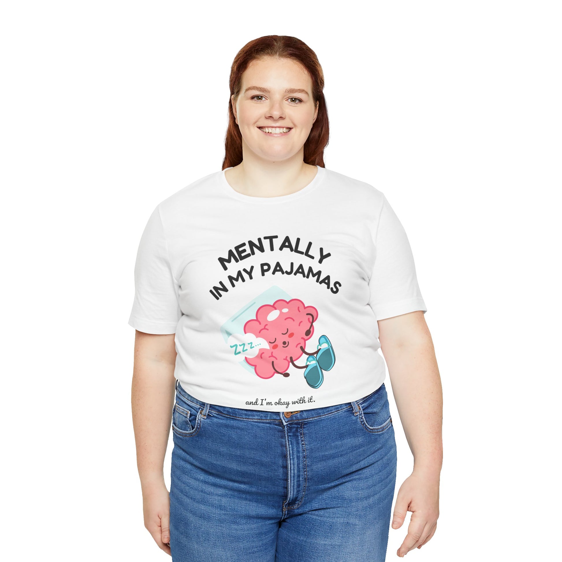 Person wearing a white t-shirt with a graphic and text 'Mentally in my pajamas and I'm ok with it', standing against a white background