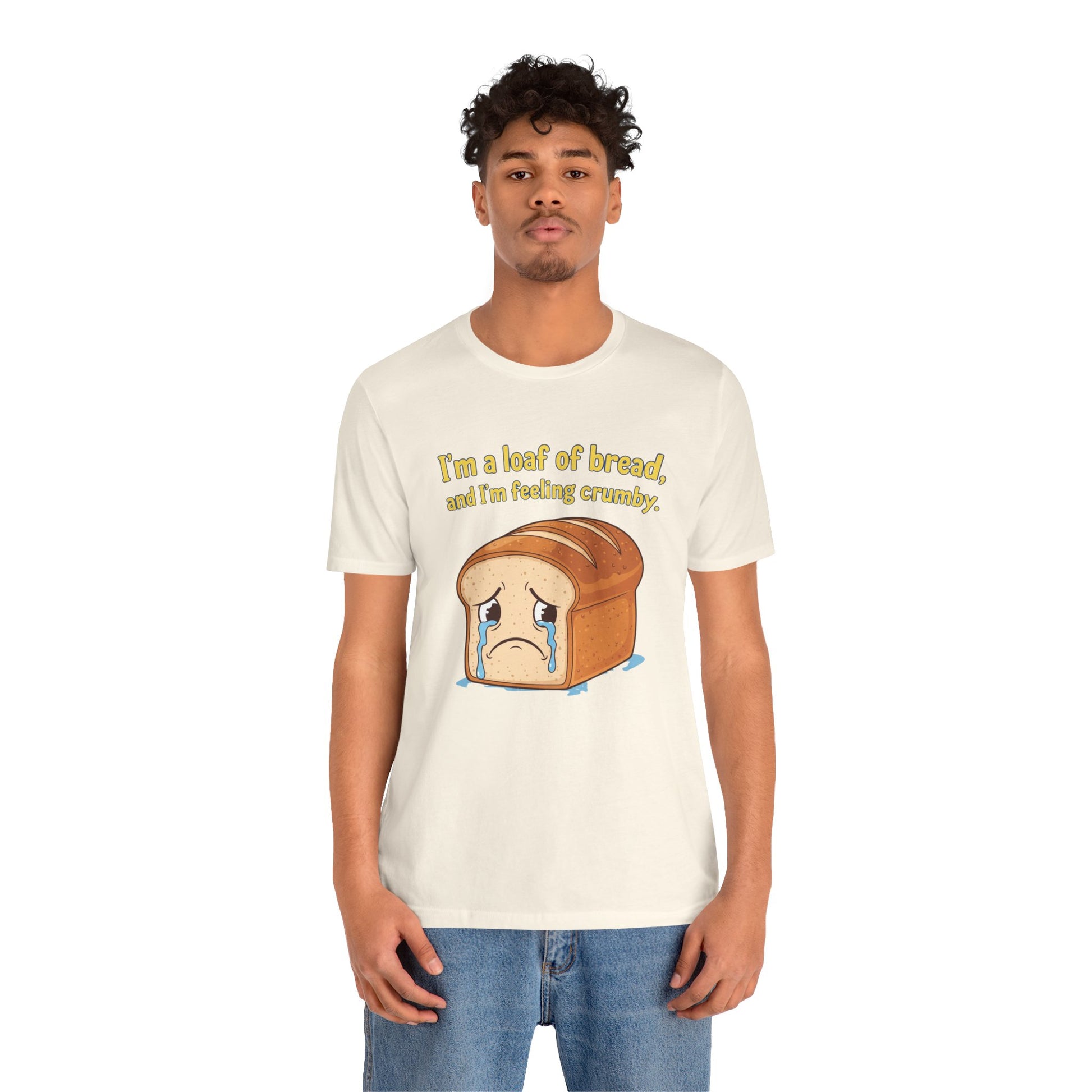 Person wearing a natural  t-shirt with a bread graphic and text on a white background. The text says, "I'm a loaf of bread, and I'm feeling crumby"