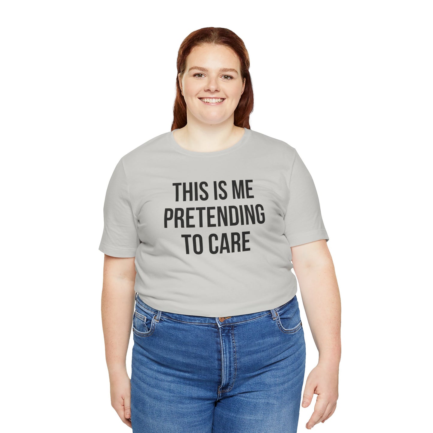 Person wearing a gray t-shirt with text 'This is me pretending to care' on a white background
