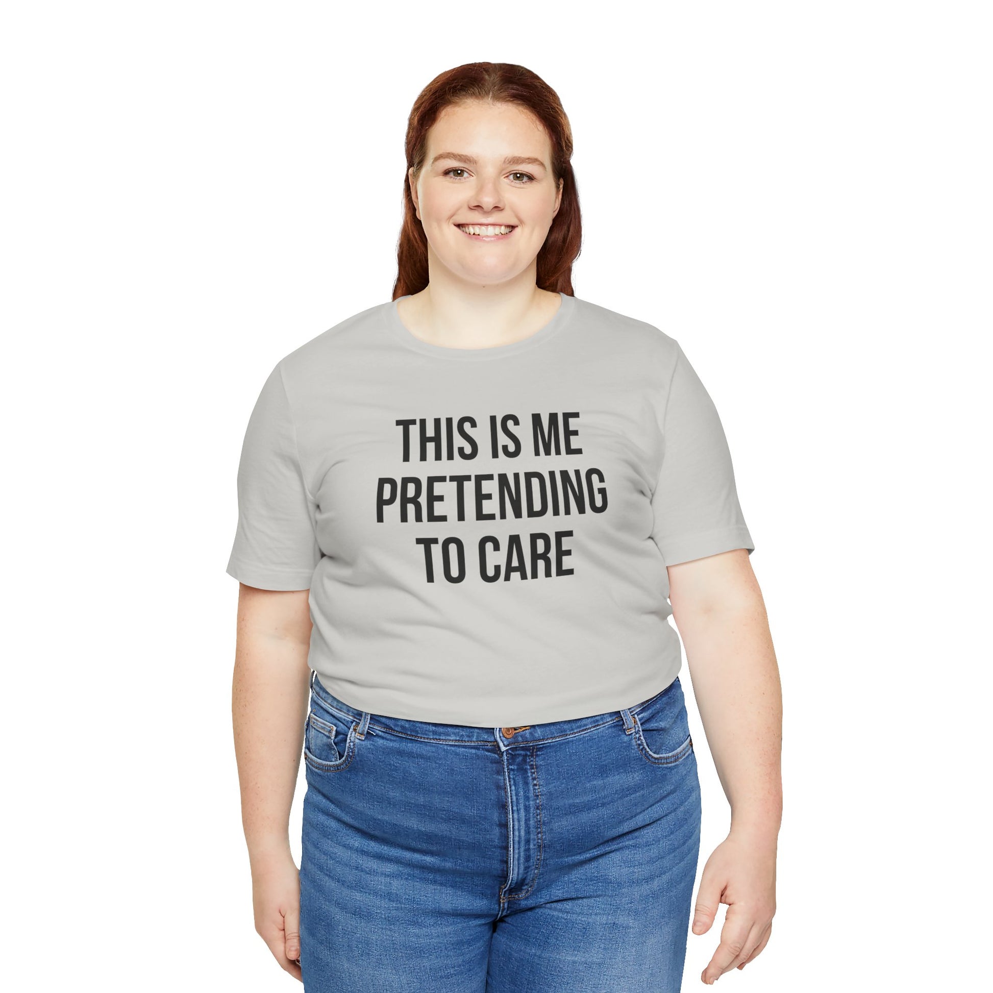 Person wearing a gray t-shirt with text 'This is me pretending to care' on a white background