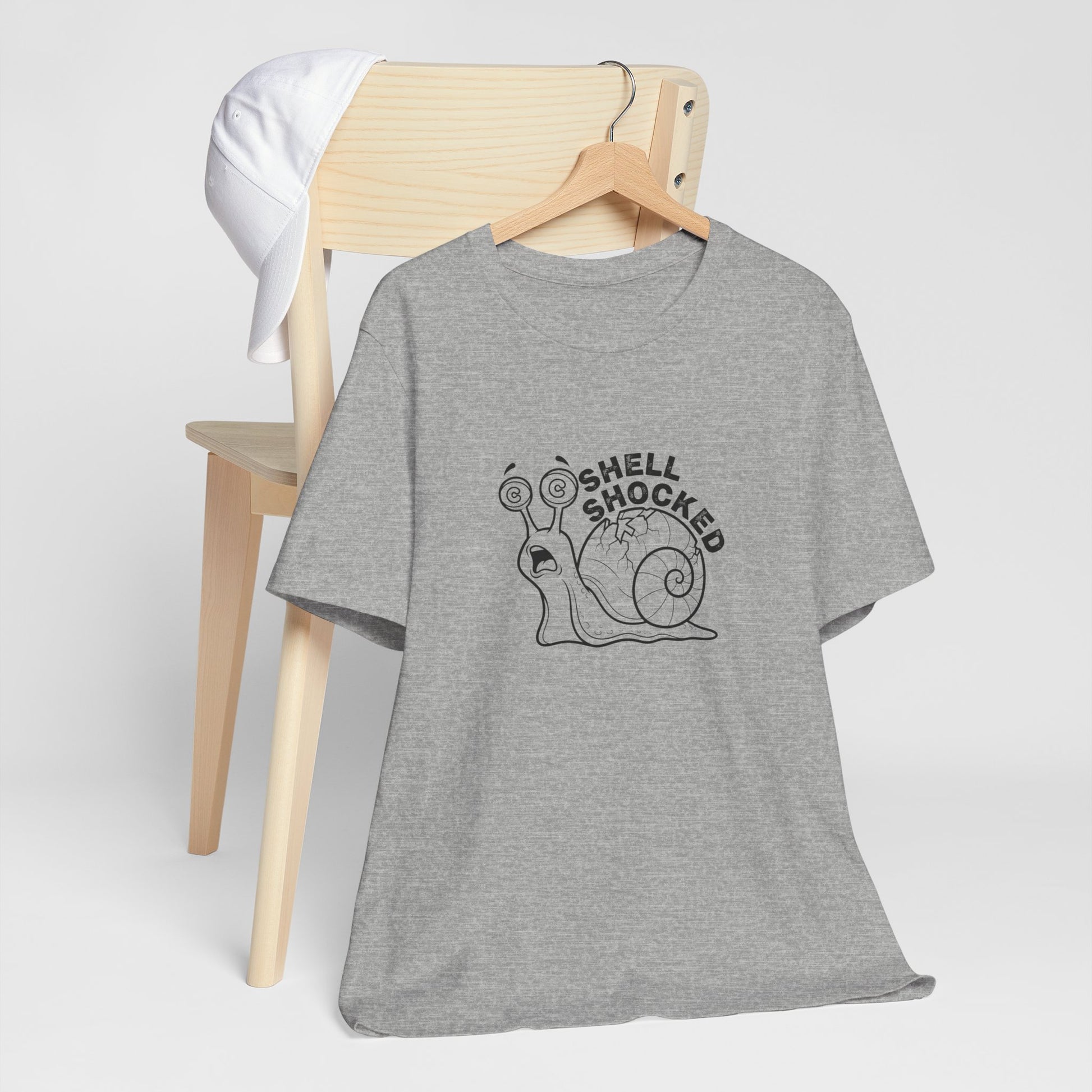 Gray t-shirt with a shell shocked snail graphic on a wooden chair against a white background