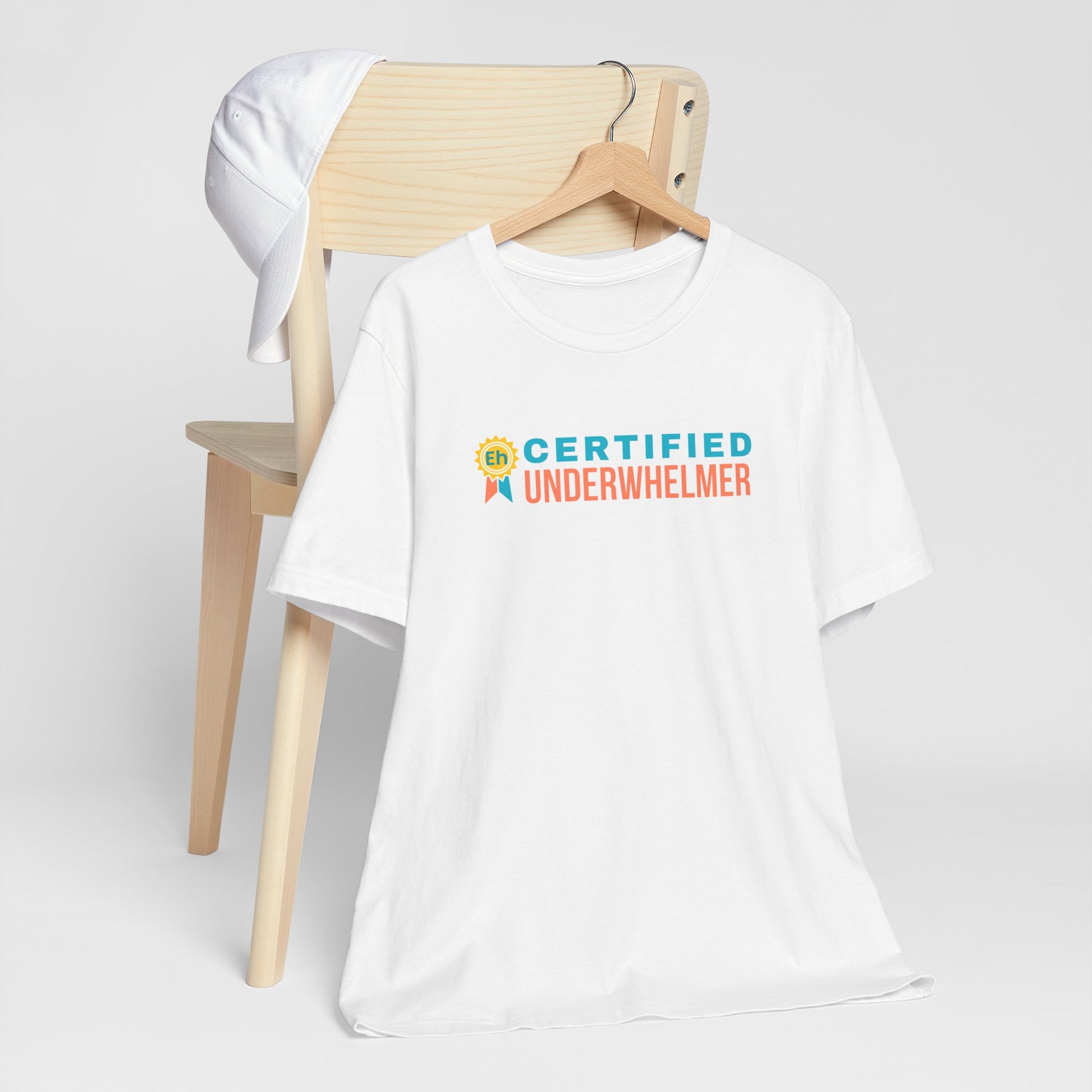 White t-shirt with 'Certified Underwhelmer' text on a white background