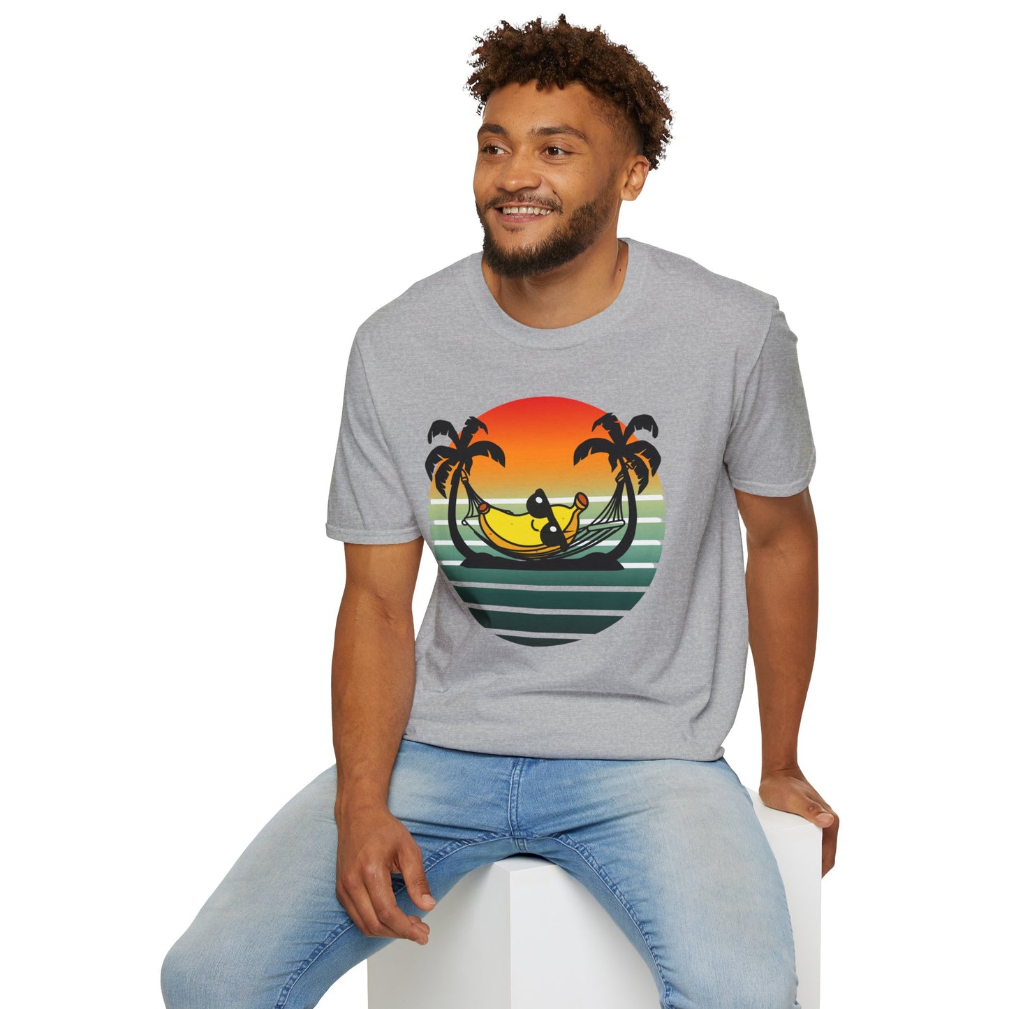 Man wearing a gray t-shirt with a colorful graphic 'banana hammock' design sitting on a white stool.