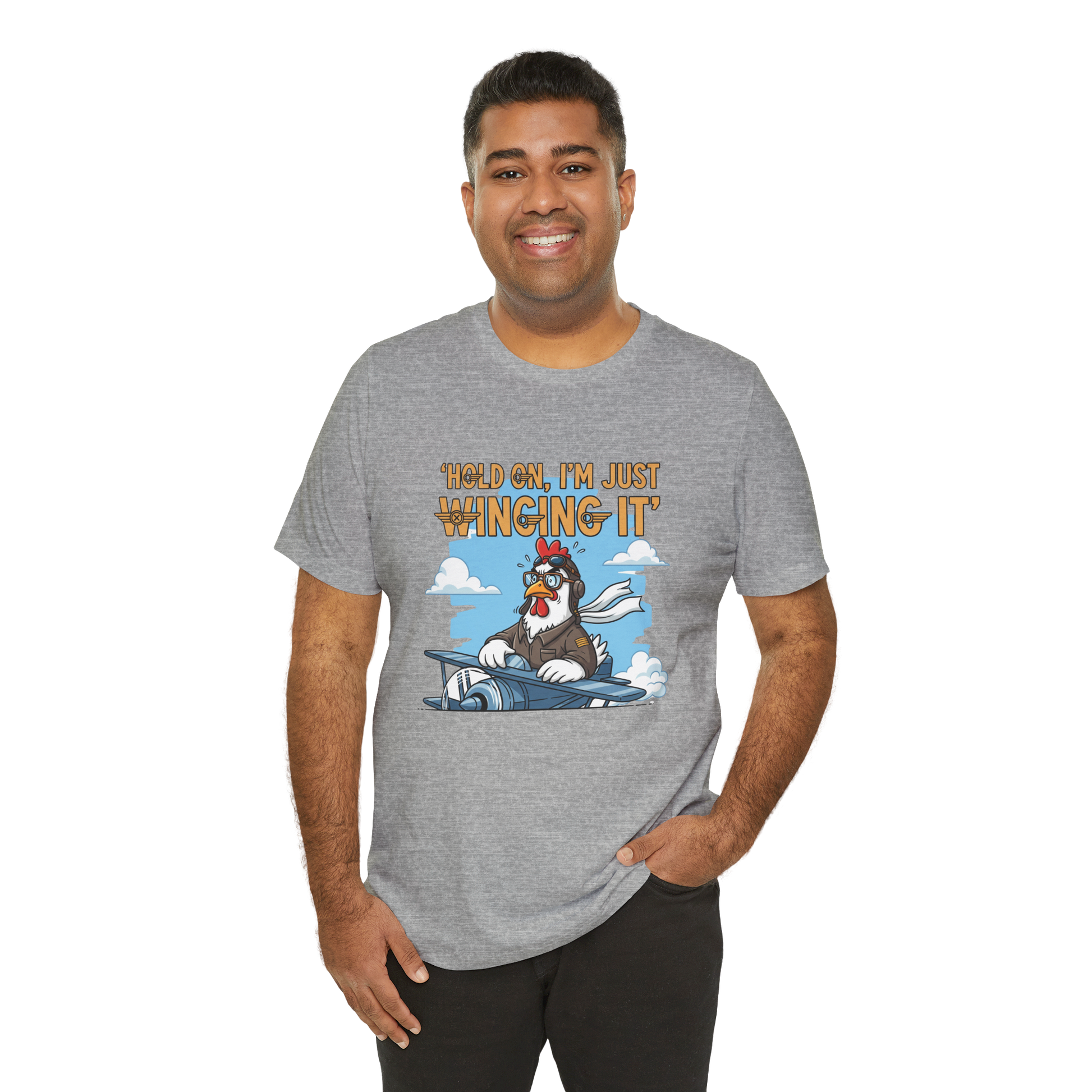 Man wearing a gray t-shirt with a cartoon character and text 'Hold on, I'm just winging it' on a white background