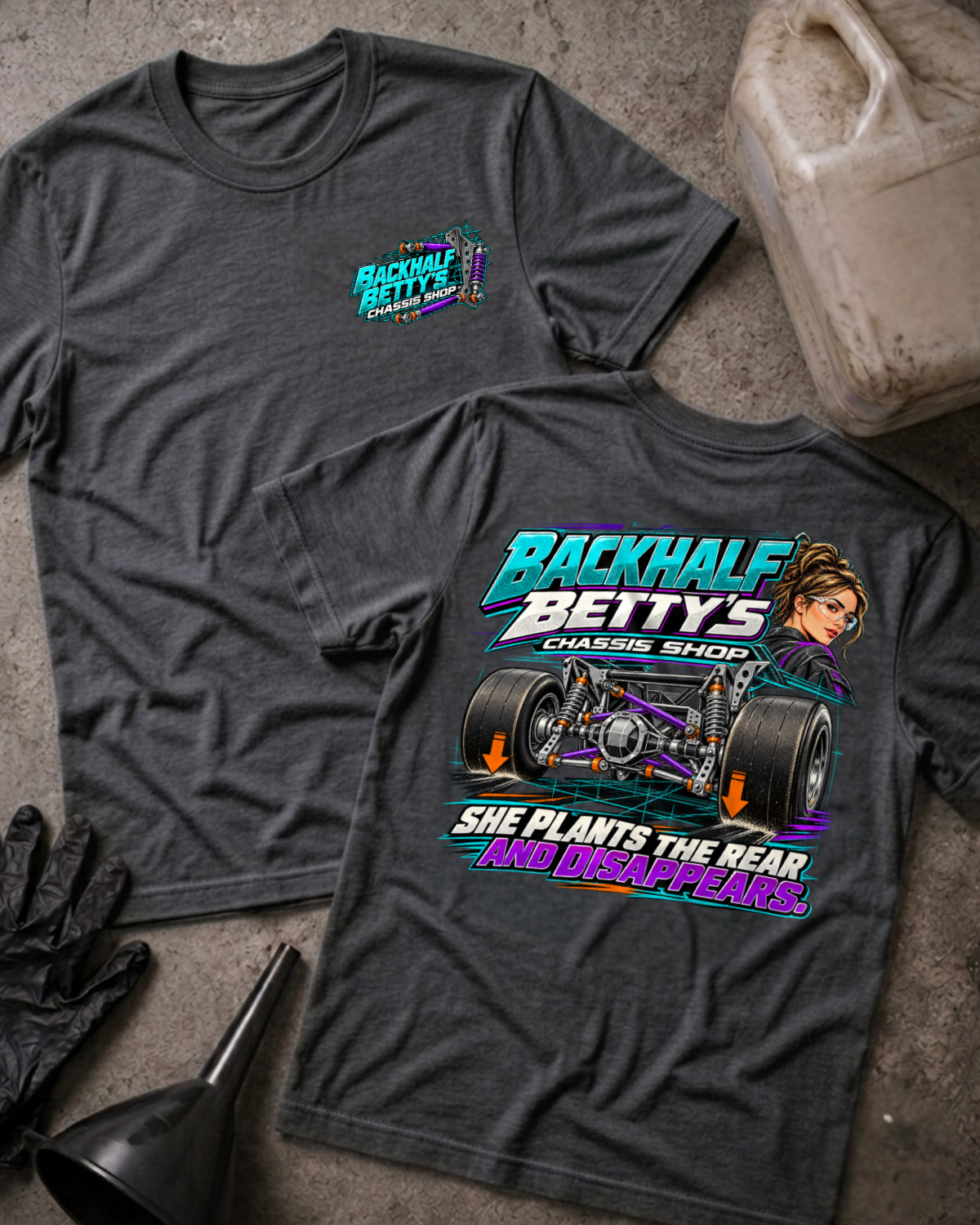 Dark Grey Heather Backhalf Betty’s T-shirt, front and back views, with chest logo and rear chassis, wide racing tires, woman illustration, and “She plants the rear and disappears.”