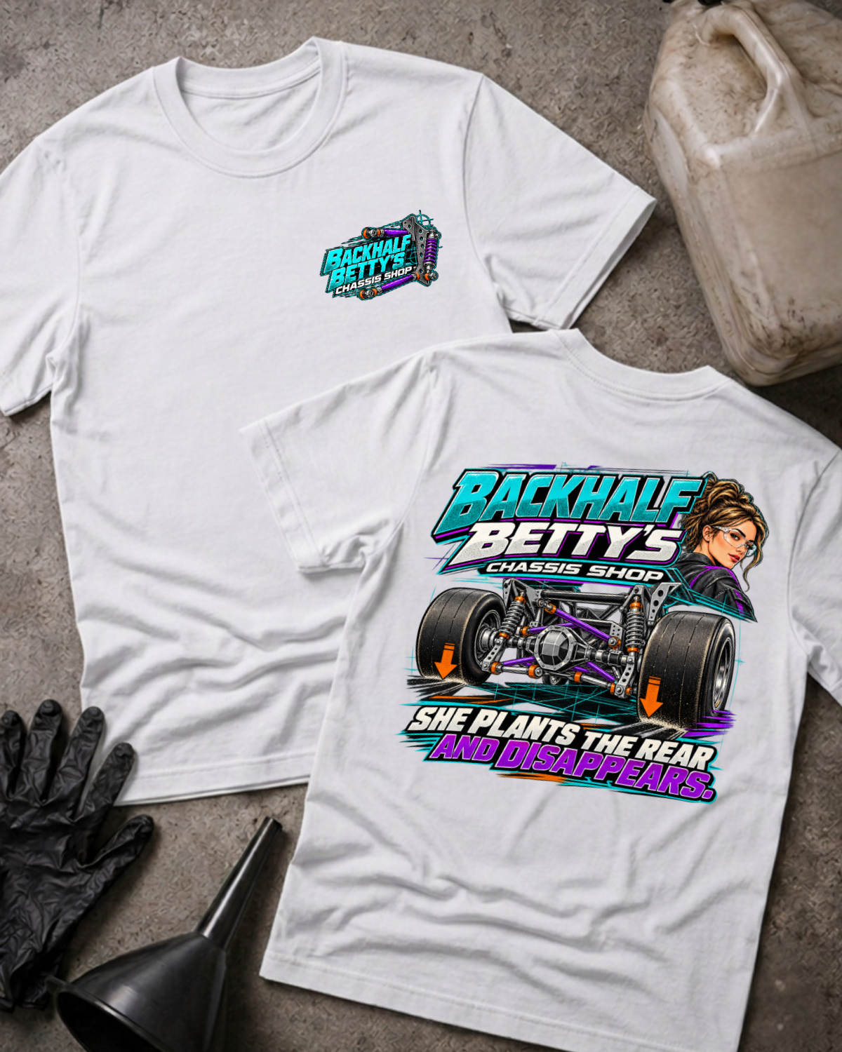 White Backhalf Betty’s T-shirt, front and back views, with chest logo and teal-and-purple chassis graphic featuring wide racing tires and “She plants the rear and disappears.”