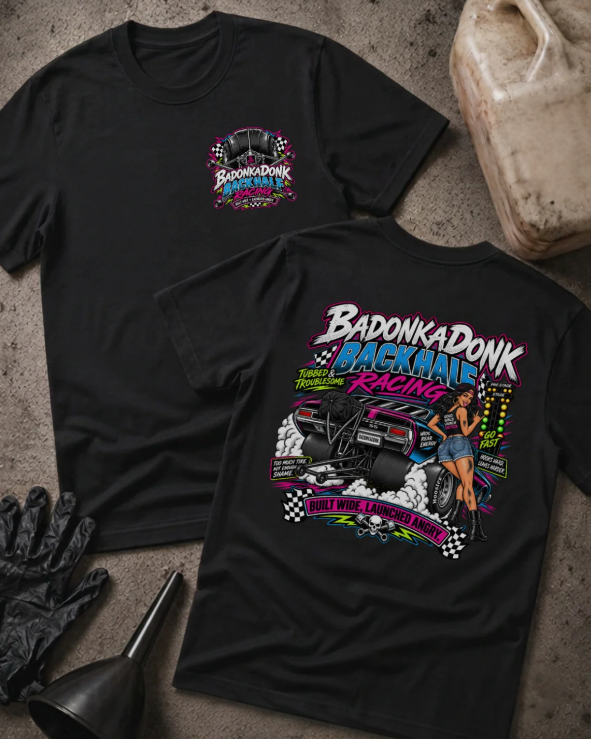 Front and back of Badonkadonk Backhalf Racing black T-shirt with chest logo, woman beside a drag car with wide rear tires and wheelie bars, and “Built wide, launched angry” slogan.
