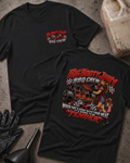 Big Booty Judy BBQ Crew T-shirt in black, flat lay showing the front chest logo and the back graphic reading Big Booty Judy BBQ Crew, When She's Done With Your Meat It's Going to Be Tender, styled with work gloves, a funnel, and a fluid jug.