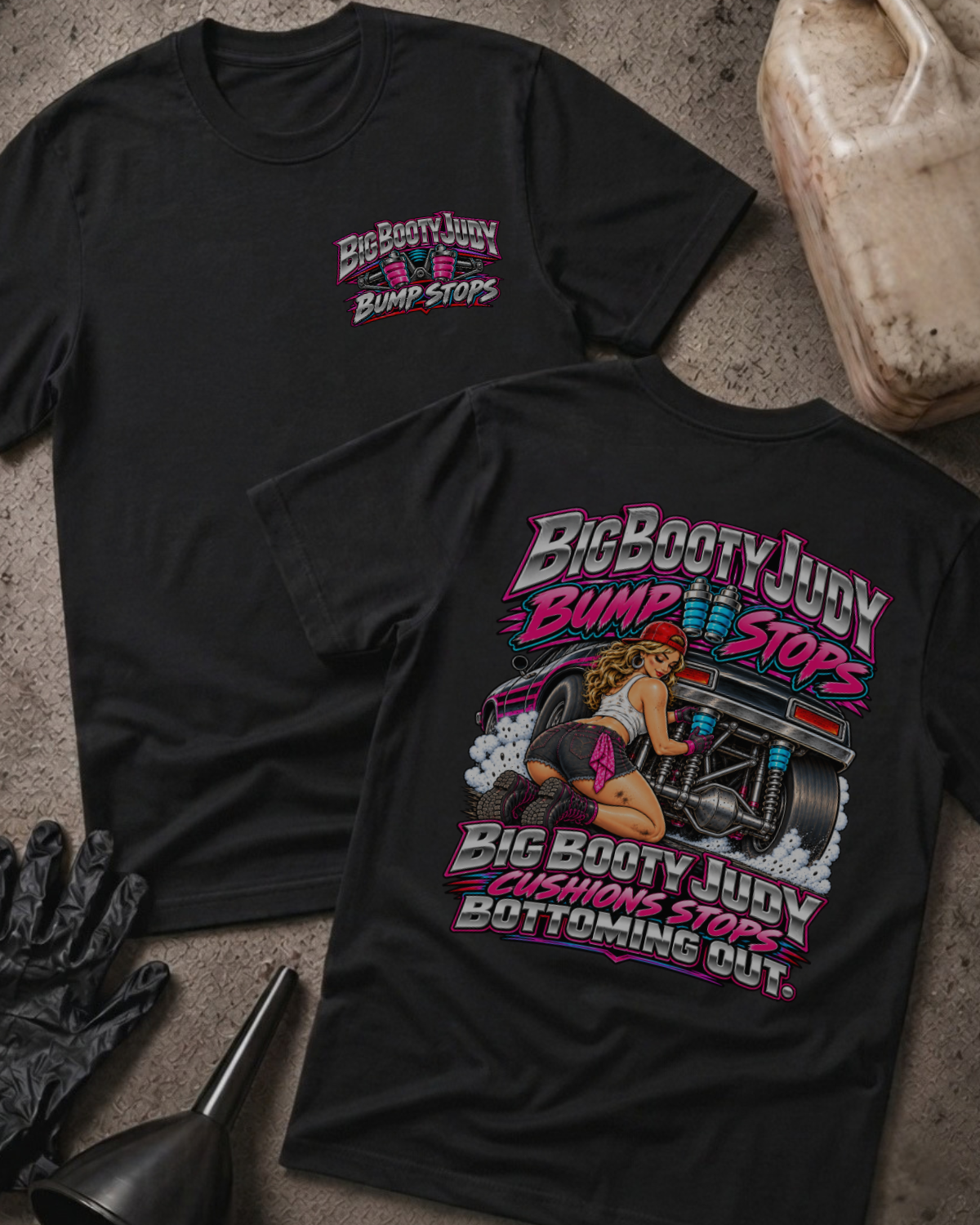 Black Big Booty Judy Bump Stops T-shirt, front and back views with a chest logo and pinup-style woman beside a drag car, plus “Big Booty Judy cushions stops bottoming out.”