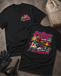 Two black graphic T-shirts displayed on a textured gray surface with racing-themed props, including a jerrycan, gloves, and funnel. The front shirt shows a small chest graphic, while the back shirt features a large colorful racing pin-up girl and race car graphic with the text 'Big Booty Judy Racing Club' and 'On A Pass Gapping Your Ass'