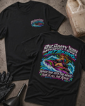 Black Big Booty Judy Jet Skiing T-shirt, showing a small front chest logo and colorful back graphic of Judy riding a jet ski with “When she hits the wave she is all the rave.”