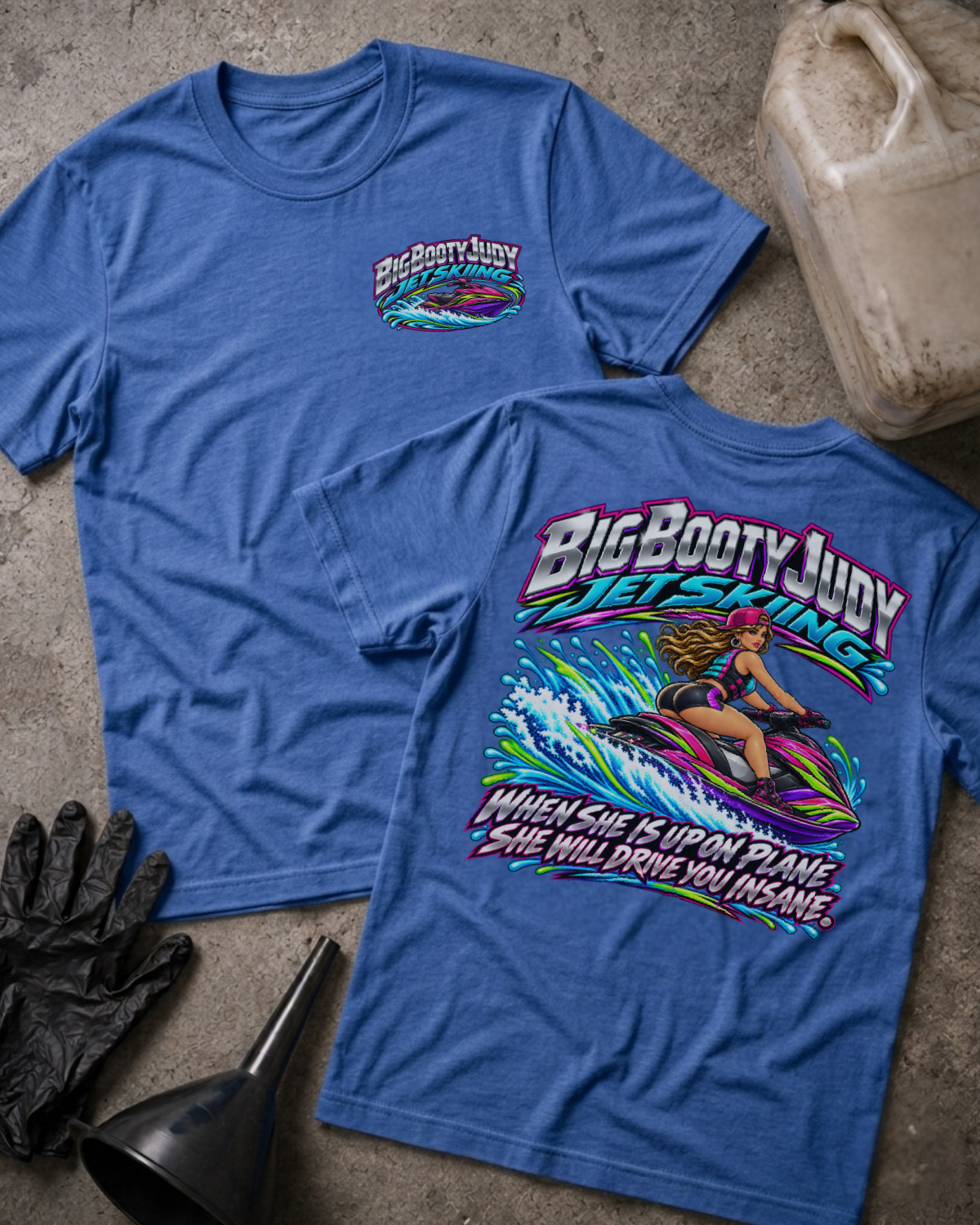 Heather True Royal Big Booty Judy Jet Skiing T-shirt showing a small front chest logo and large back print of a woman riding a neon-colored jet ski through splashing water.