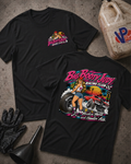 Two black graphic T-shirts laid flat on a textured gray surface, with racing-themed artwork and text. One shirt shows a small chest graphic, and the other shows a large back graphic with the words 'Big Booty Judy Racing Club' and 'Hookin' Hard and Haulin' Ass'