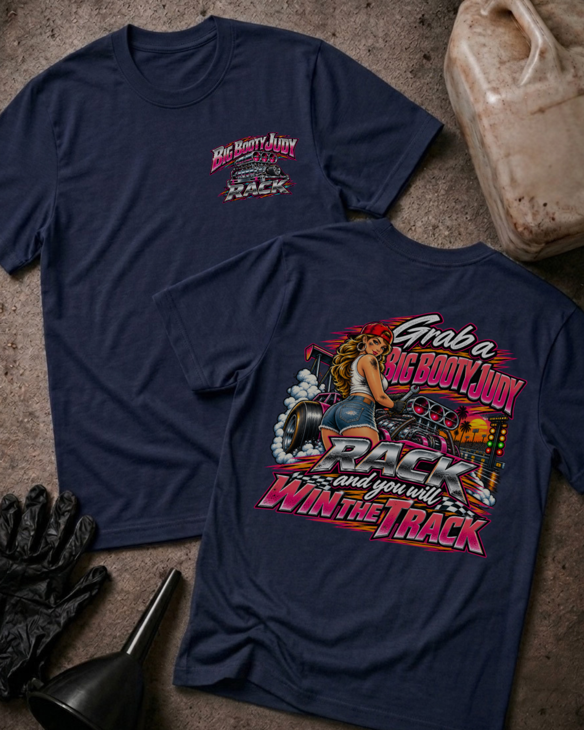 Big Booty Judy Rack To Win The Track T-shirt in navy, flat lay showing the front chest logo and the back graphic reading Grab a Big Booty Judy Rack and You Will Win the Track, styled with work gloves, a funnel, and a fluid jug.
