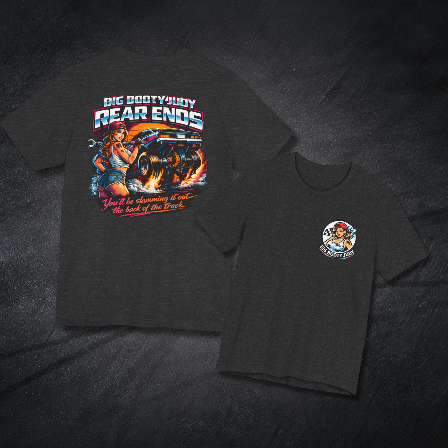 Dark grey heather t-shirt with Big Booty Judy Rear Ends graphic design and a Big Booty Judy logo on a dark textured background 