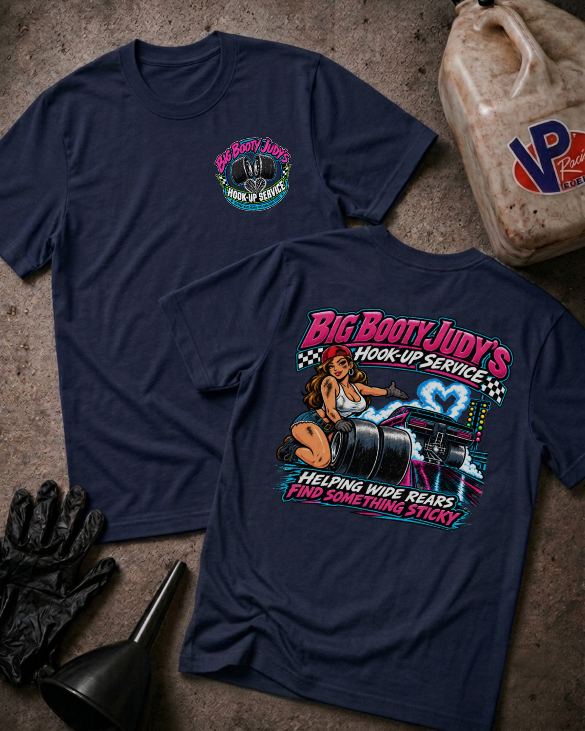 Tgraphic t-shirts showing a 'BIG BOOTY JUDY HOOK-UP SERVICE' logo on the front and a colorful graphic of a woman with racing slicks and 'BIG BOOTY JUDY'S HOOK-UP SERVICE HELPING WIDE REARS FIND SOMETHING STICKY' text on the backwo navy 
