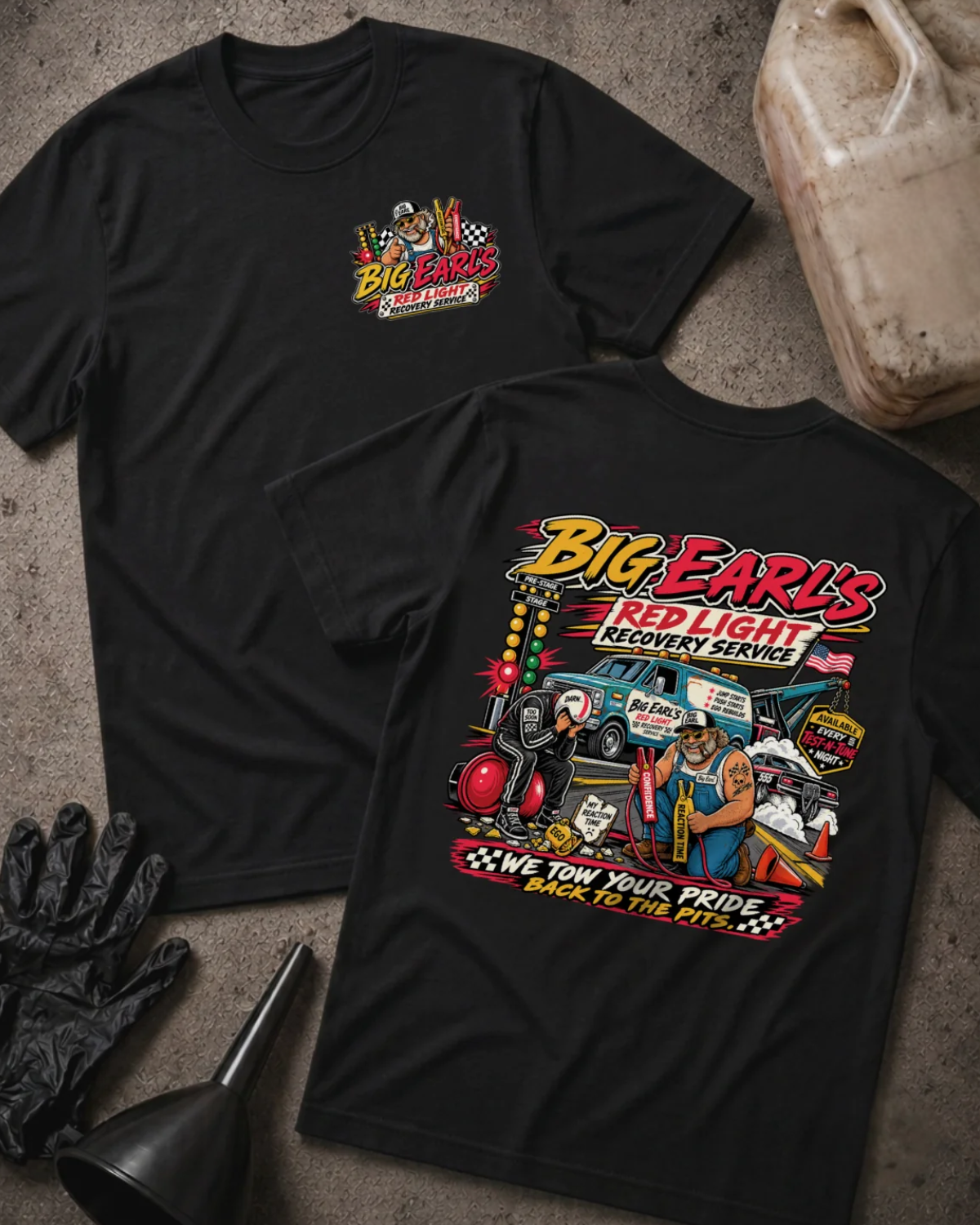 Front and back of Big Earl’s Red Light Recovery black T-shirt with chest logo, tow truck, mechanic and helmeted racer beside a red starting light, and “We tow your pride back to the pits” slogan.