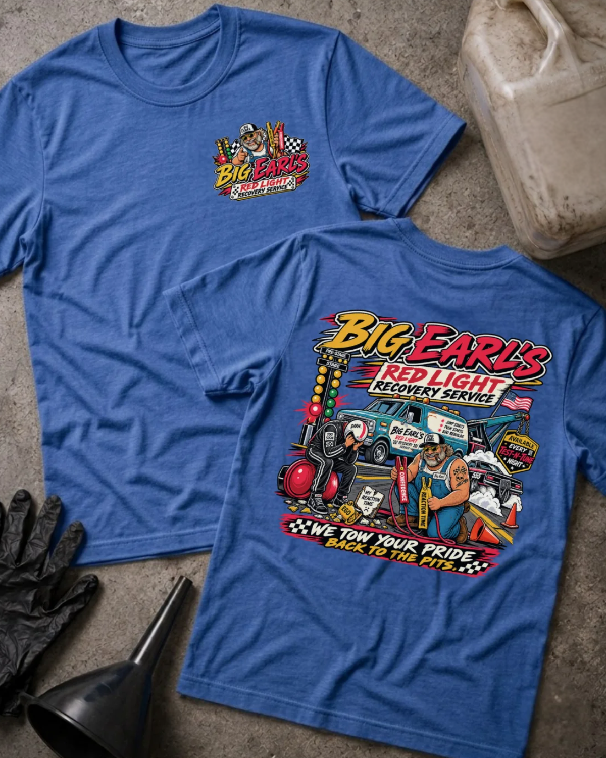 Front and back of Big Earl’s Red Light Recovery heather true royal T-shirt with chest logo, tow truck, mechanic and helmeted racer beside a red starting light, and “We tow your pride back to the pits” slogan.