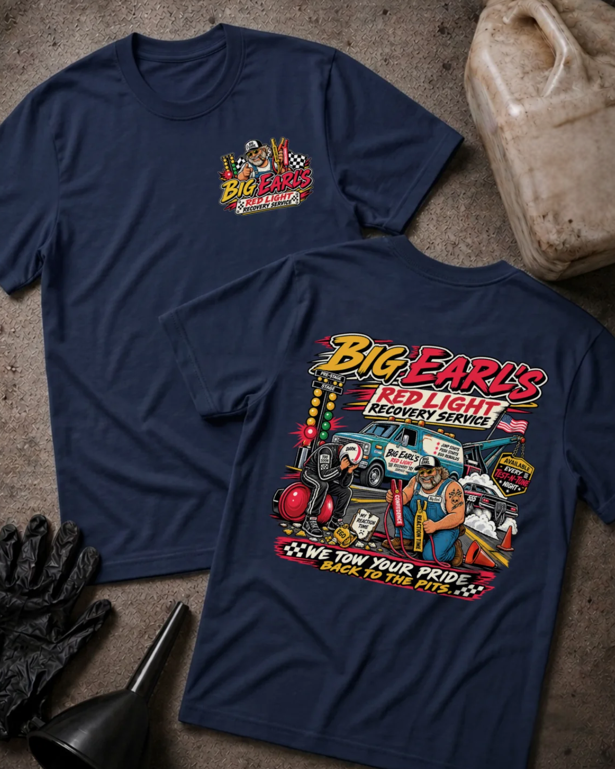 Front and back of Big Earl’s Red Light Recovery navy T-shirt with chest logo, tow truck, mechanic and helmeted racer beside a red starting light, and “We tow your pride back to the pits” slogan.