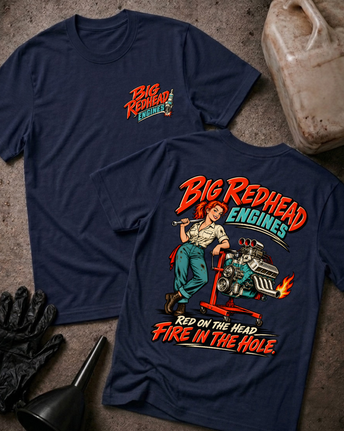 Navy Big Redhead Engines T-shirt showing the front spark-plug logo and back cartoon of a redhead woman by an engine stand with a supercharged V8 and flaming headers, “Red on the Head, Fire in the Hole,” with gloves, funnel, and oil jug.