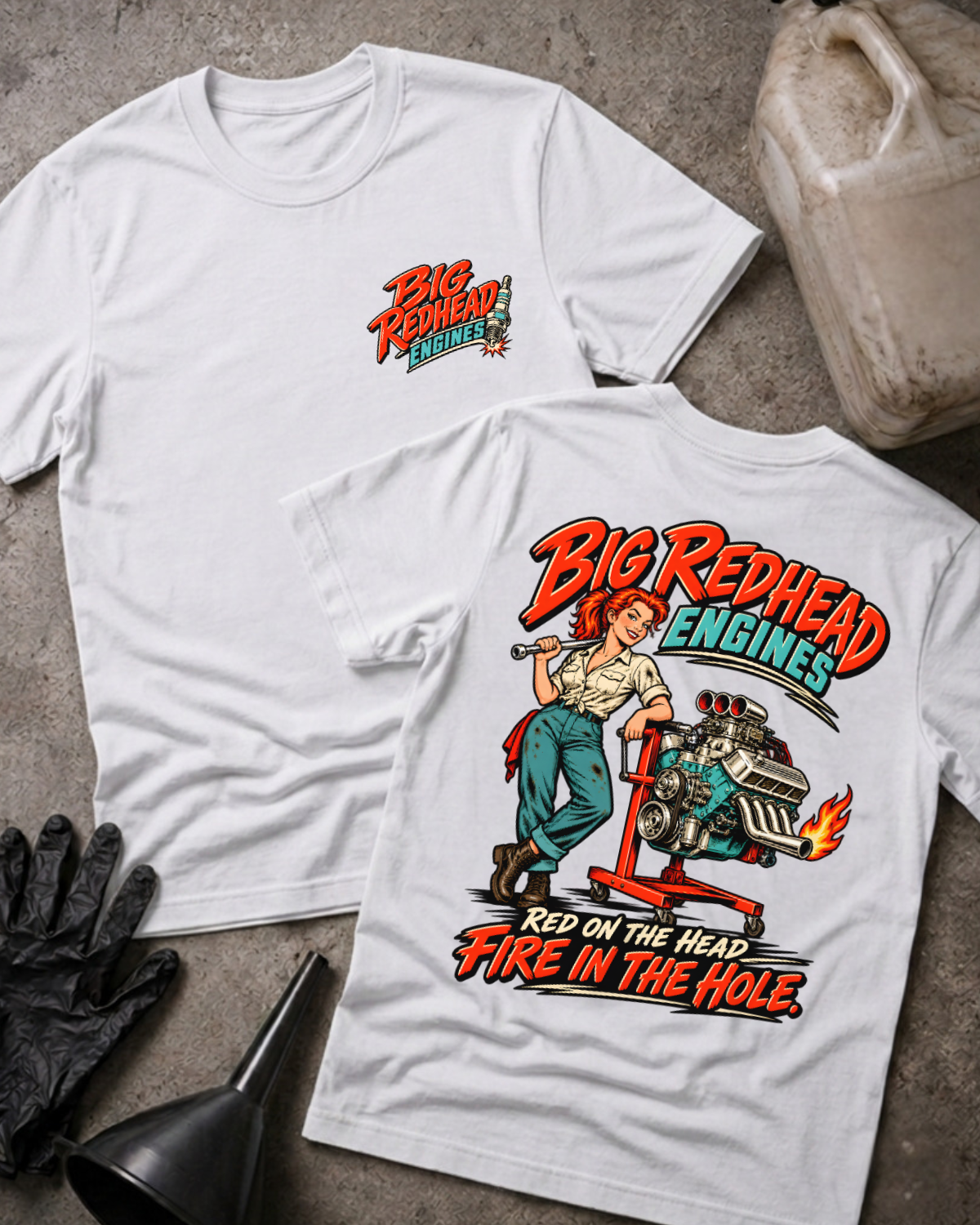 White Big Redhead Engines T-shirt showing the front spark-plug logo and back cartoon of a redhead woman by an engine stand with a supercharged V8 and flaming headers, “Red on the Head, Fire in the Hole,” with gloves, funnel, and oil jug.