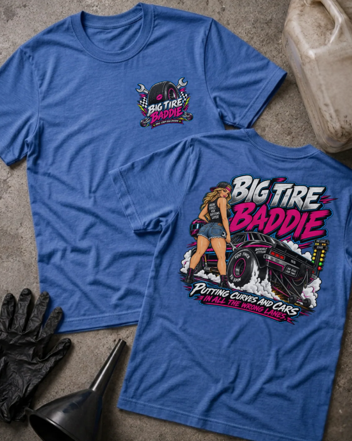 Front and back of Big Tire Baddie heather true royal T-shirt with chest logo, woman beside a drag car with wide rear tires, and “Putting curves and cars in all the wrong lanes” slogan.