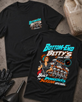 Black Bottom End Betty’s Engine Works T-shirt showing the front chest logo and back cartoon of a woman mechanic with a torque wrench by a V8 engine’s crankshaft and pistons, “Built Downstairs to Scream Upstairs,” with gloves, funnel, and oil jug.