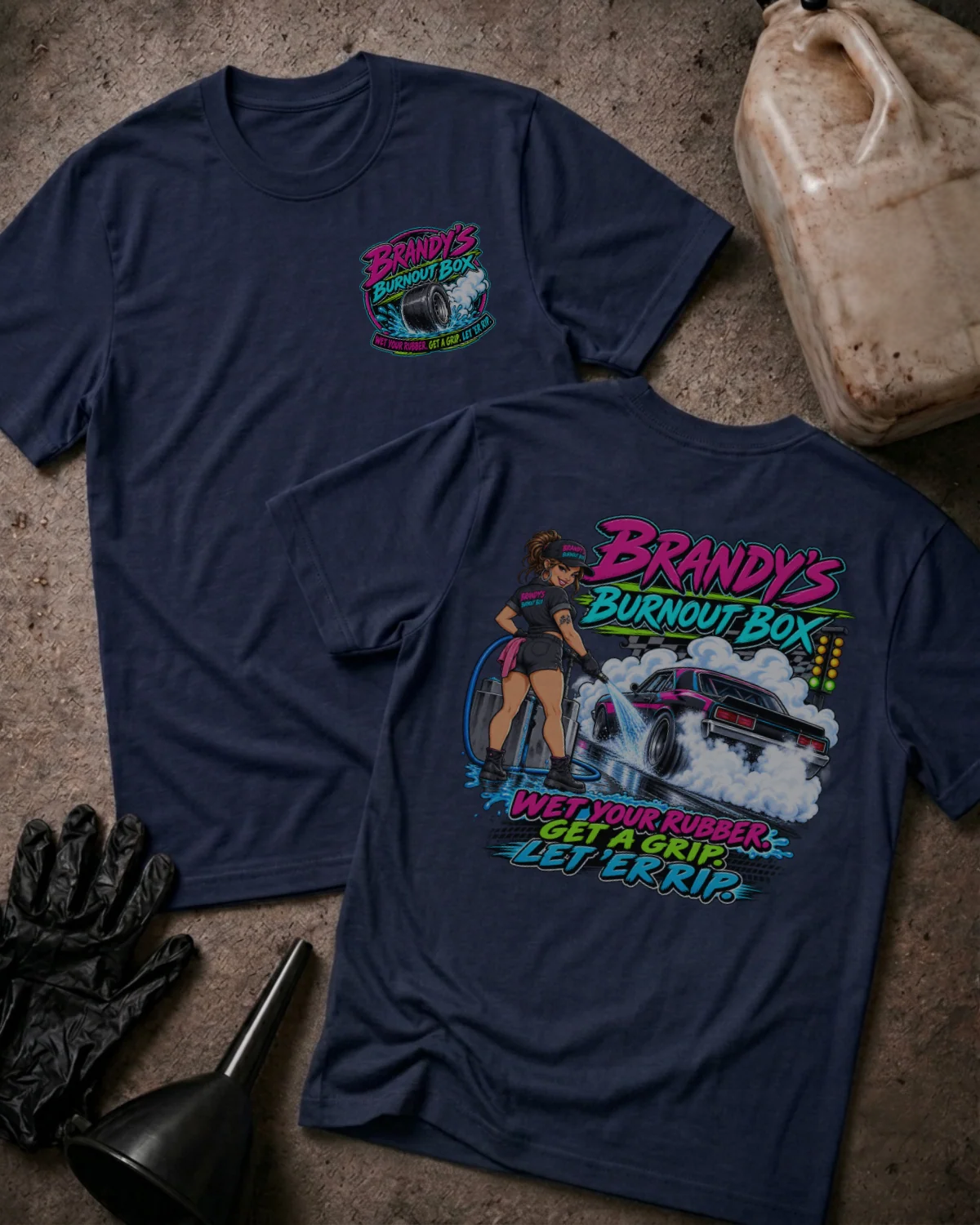 Front and back of Brandy’s Burnout Box navy T-shirt with chest logo and colorful woman and drag car burnout graphic reading “Wet Your Rubber, Get a Grip, Let ’Er Rip.”