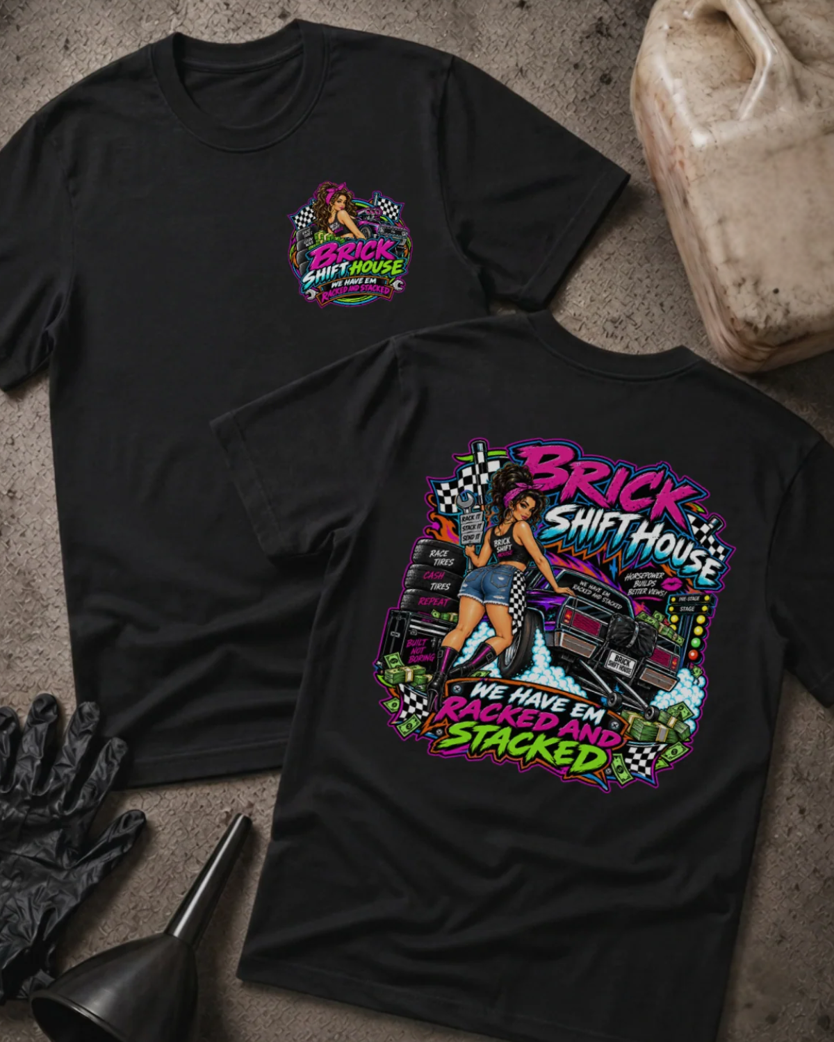 Front and back of Brick Shift House black T-shirt with chest logo, woman beside stacked racing tires and a drag car, and “We have ’em racked and stacked” slogan.