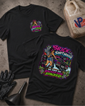 Two black graphic T-shirts laid flat on a textured concrete surface, with a gas bottle, black gloves, and funnel as styling props. The front shirt shows a small multicolor chest graphic, and the back shirt shows a large colorful graphic with the words 'Brick Shift House' and 'We Have Em Racked And Stacked'.