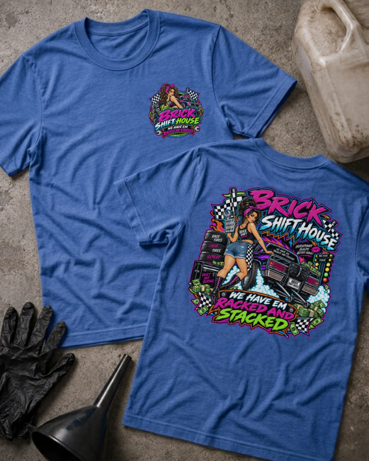 Front and back of Brick Shift House heather true royal T-shirt with chest logo, woman beside stacked racing tires and a drag car, and “We have ’em racked and stacked” slogan.