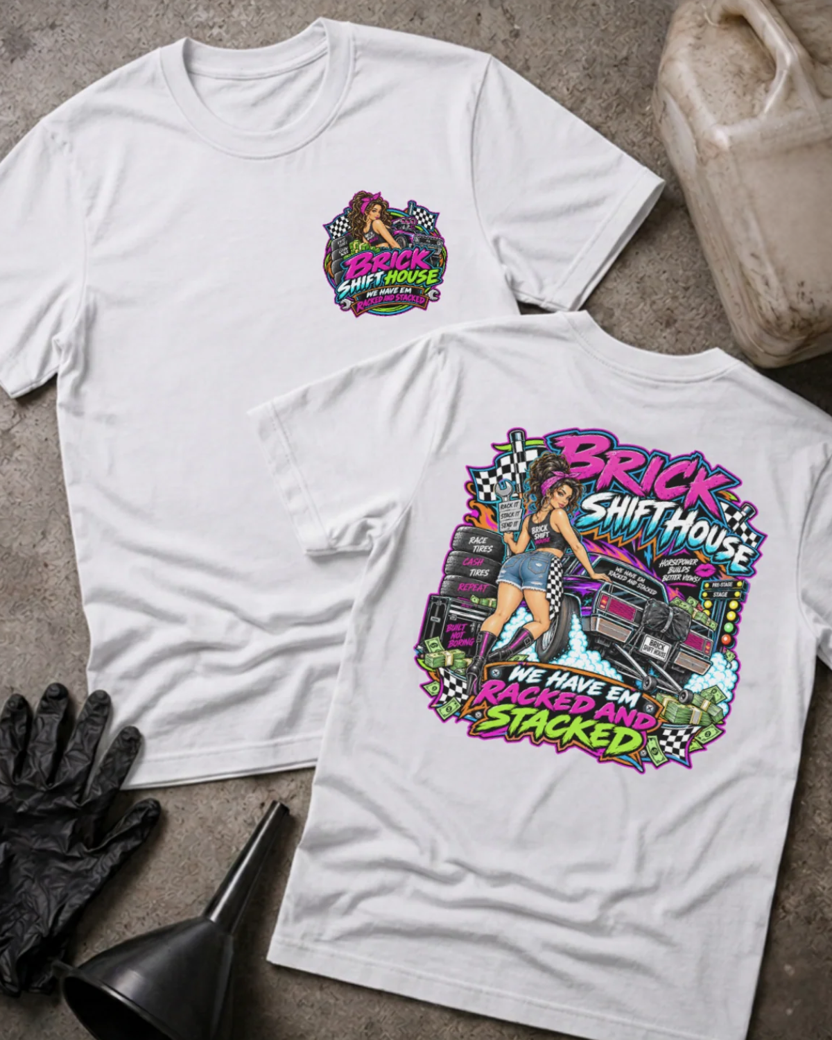 Front and back of Brick Shift House white T-shirt with chest logo, woman beside stacked racing tires and a drag car, and “We have ’em racked and stacked” slogan.
