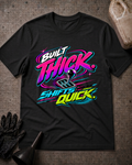 Black T-shirt laid flat with “Built Thick, Shifts Quick” lettering in neon pink, cyan and lime around a manual gear-shift graphic.