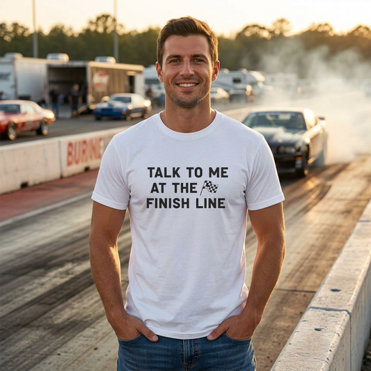 Man wearing a white t-shirt with 'Talk to me at the finish line' text on a race track.