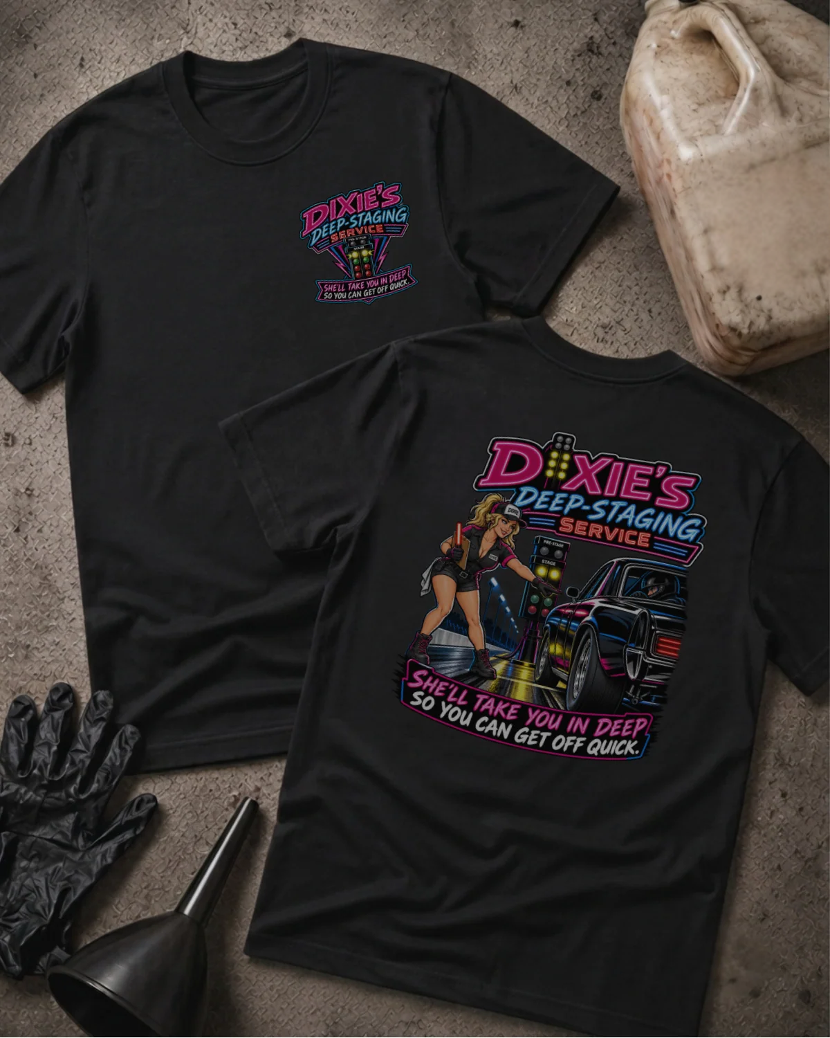 Front and back of Dixie’s Deep Staging Service black T-shirt with chest logo, woman beside a drag car and staging lights, and “She’ll take you in deep so you can get off quick” slogan.
