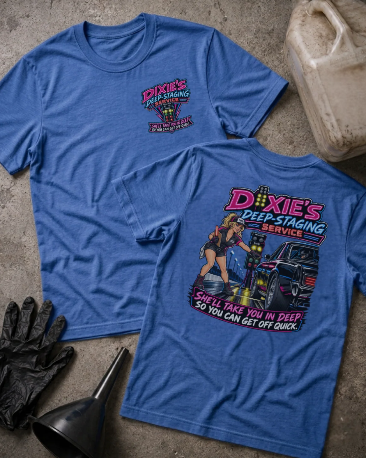 Front and back of Dixie’s Deep Staging Service heather true royal T-shirt with chest logo, woman beside a drag car and staging lights, and “She’ll take you in deep so you can get off quick” slogan.
