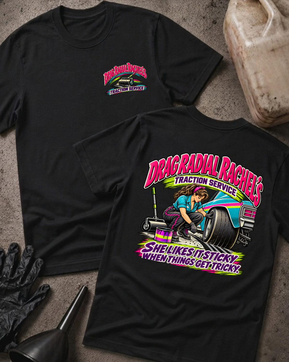 Black Drag Radial Rachel’s Traction Service T-shirt, front and back views, with chest logo and woman prepping a drag racing tire above “She likes it sticky when things get tricky.”